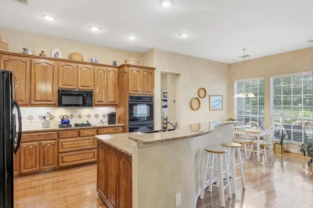 a kitchen with stainless steel appliances kitchen island granite countertop a sink and cabinets