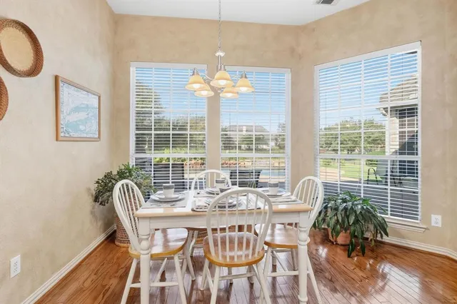 a view of a dining room with furniture wooden floor and chandelier