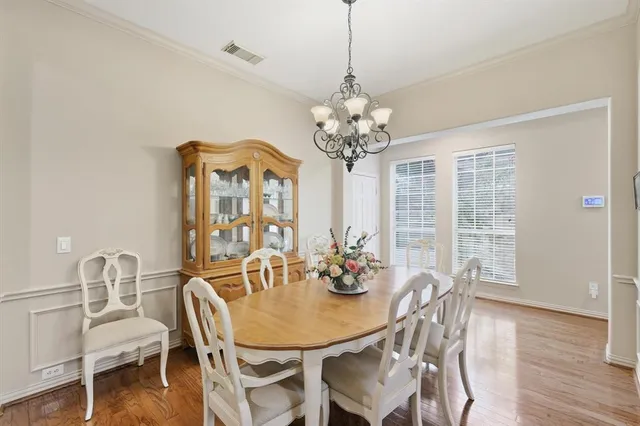 a view of a dining room with furniture wooden floor and chandelier