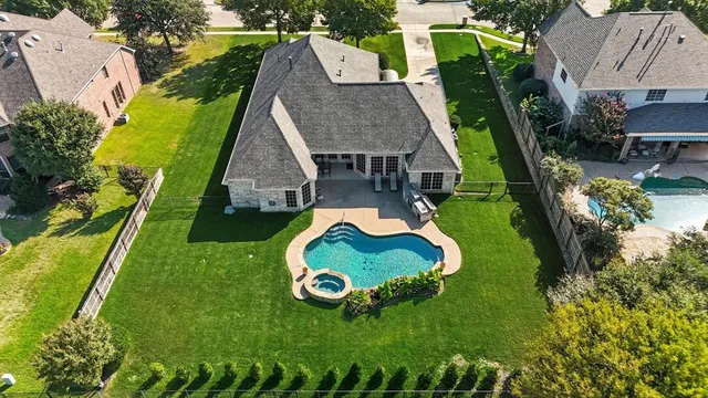 an aerial view of a house with swimming pool and garden