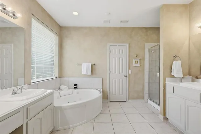 a spacious bathroom with a bathtub sink and mirror