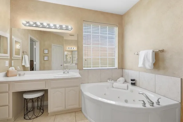 a bathroom with a bathtub a sink a mirror and a window