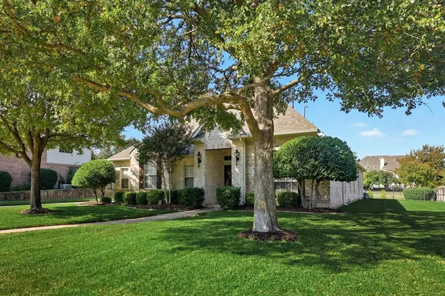 a front view of a house with a yard and tree