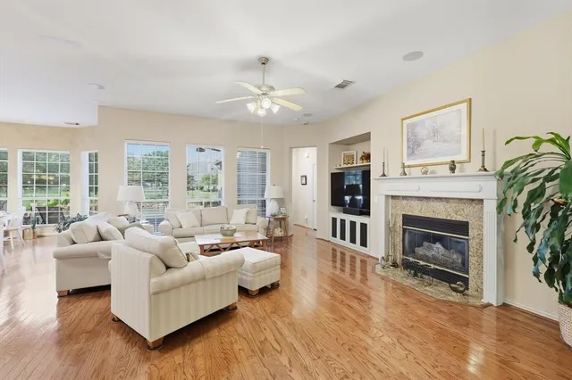a living room with furniture fireplace and large windows