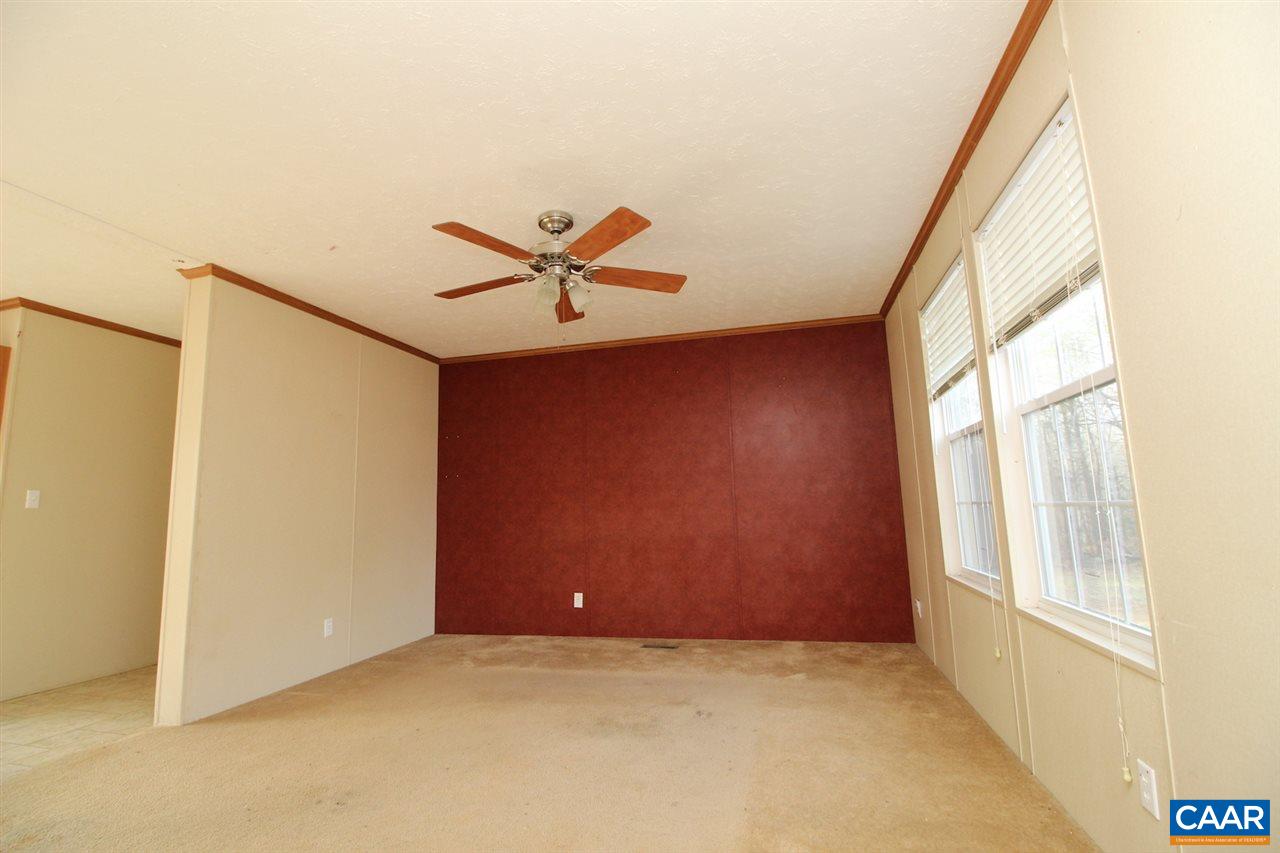 8568 Venable Road Kents Store, VA 23084 - Photo 2 of 11 an empty room with a window and a ceiling fan