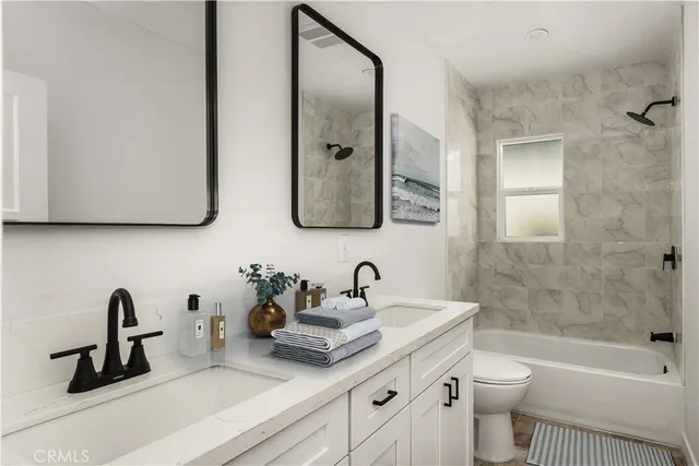 a bathroom with a double vanity sink toilet and shower