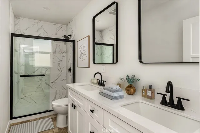 a bathroom with a sink a toilet and shower