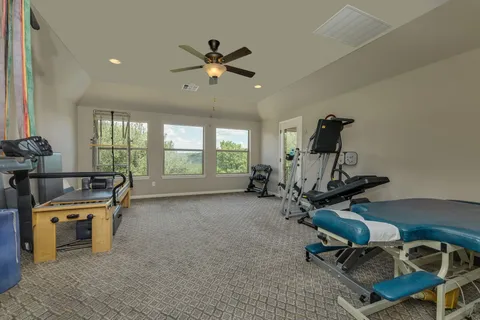 a view of a room with gym equipment and windows