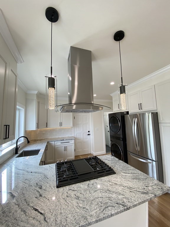 a kitchen with kitchen island stainless steel appliances a sink refrigerator stove and kitchen island