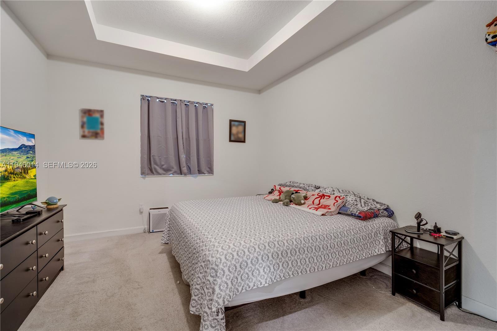 28574 Southwest 134th Court, Unit 28574 Homestead, FL 33033 - Photo 15 of 29 a bedroom with a bed and a flat screen tv