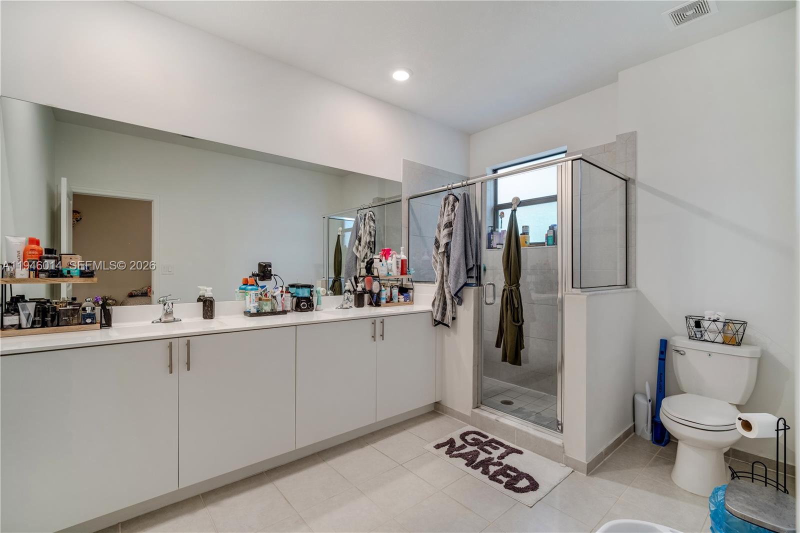 28574 Southwest 134th Court, Unit 28574 Homestead, FL 33033 - Photo 16 of 29 a bathroom with a toilet sink and mirror