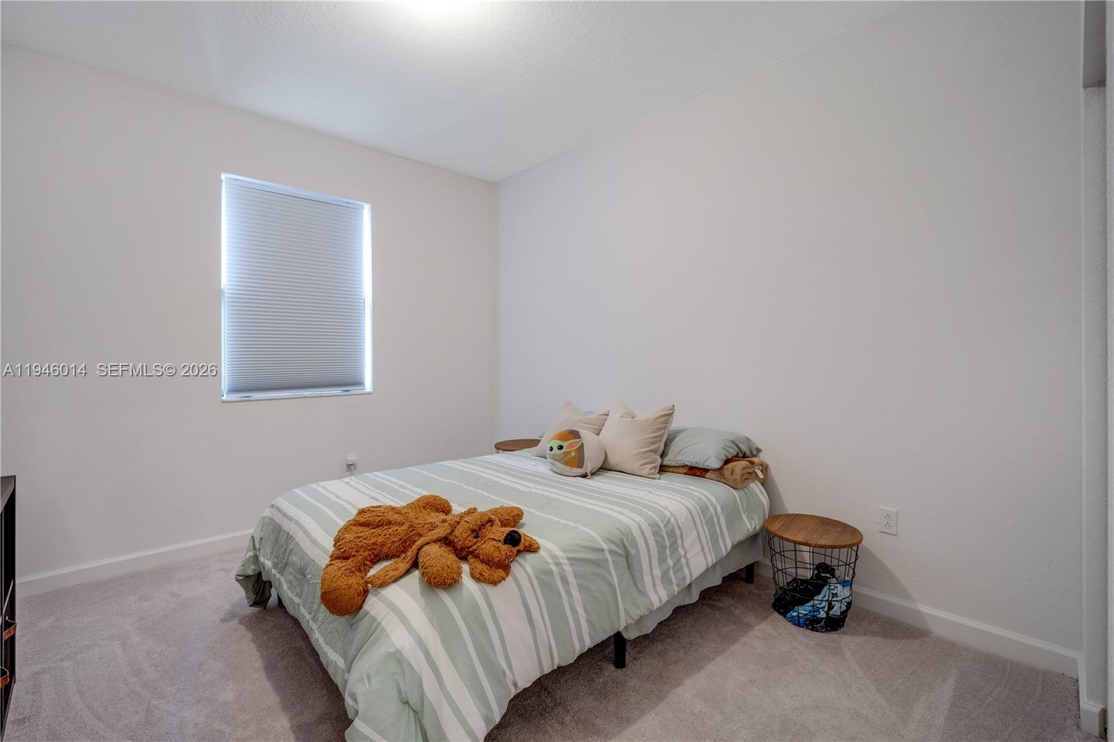 28574 Southwest 134th Court, Unit 28574 Homestead, FL 33033 - Photo 19 of 29 a bedroom with a bed and a lamp