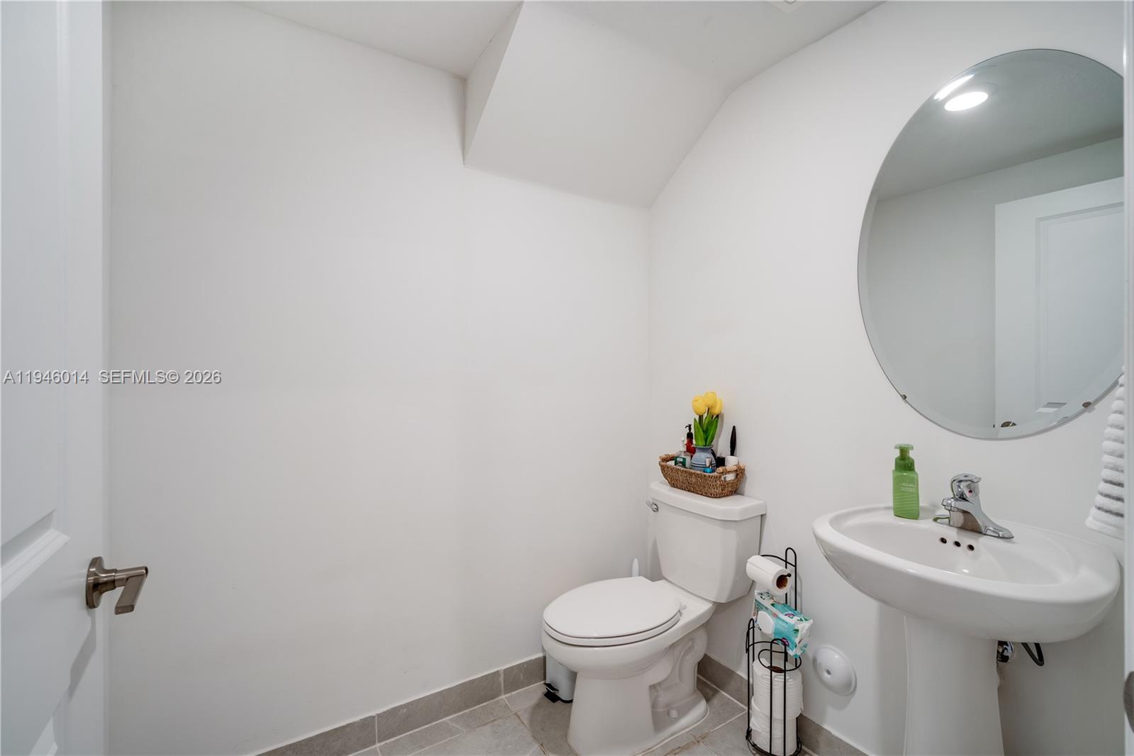 28574 Southwest 134th Court, Unit 28574 Homestead, FL 33033 - Photo 21 of 29 a bathroom with a sink mirror and toilet