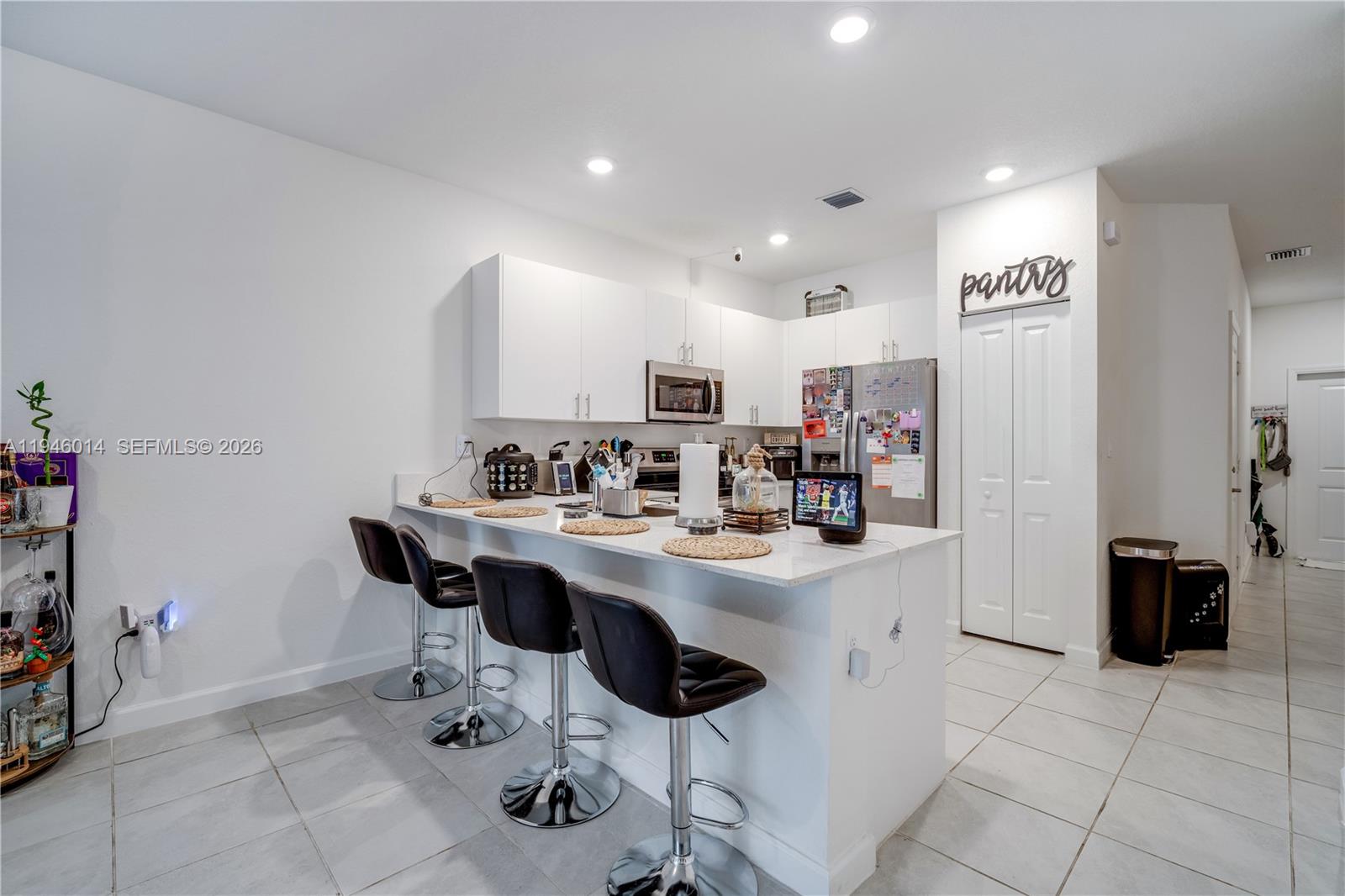 28574 Southwest 134th Court, Unit 28574 Homestead, FL 33033 - Photo 6 of 29 a kitchen with stainless steel appliances kitchen island granite countertop a sink and cabinets
