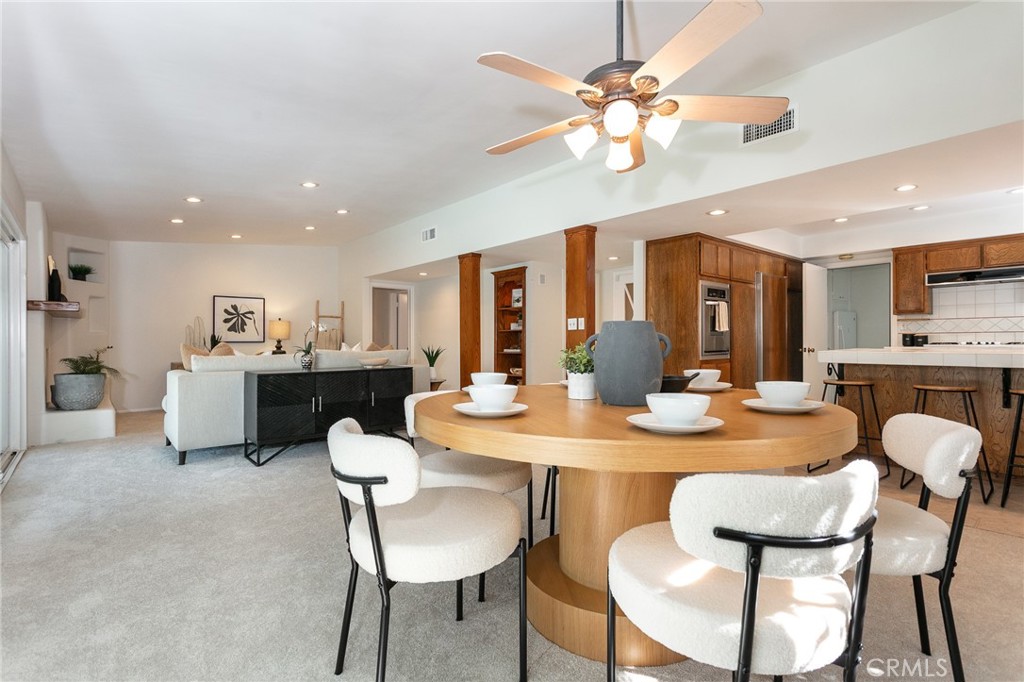 11017 Baird Avenue Porter Ranch, CA 91326 - Photo 6 of 35 a dining room with kitchen island furniture a chandelier and kitchen view
