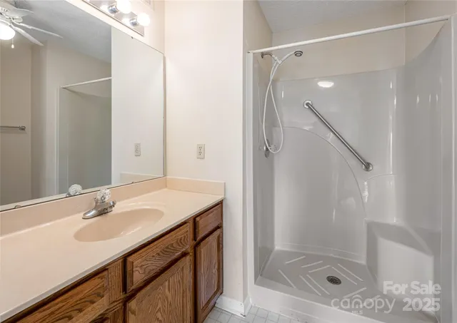 a bathroom with a sink shower and a mirror