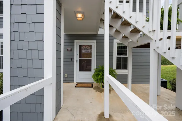 a house with a large window and potted plants in front of door