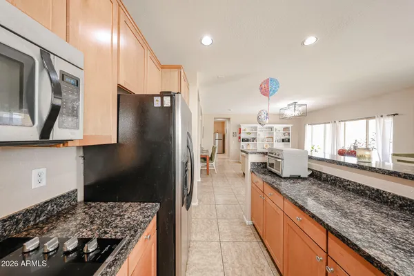 a kitchen with stainless steel appliances granite countertop a sink refrigerator and cabinets