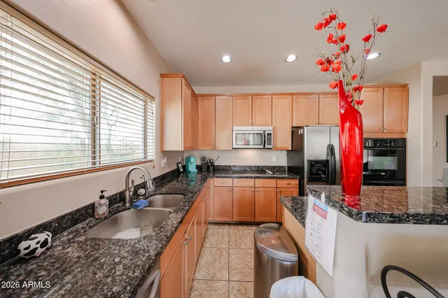 a kitchen with granite countertop a sink stove and cabinets