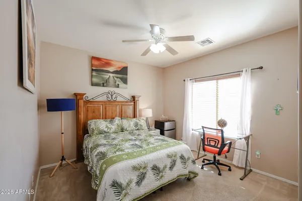 a bedroom with a bed and a painting on the wall