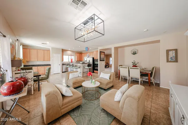 a living room with furniture kitchen view and a window