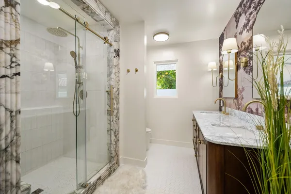 a bathroom with a sink shower and a mirror