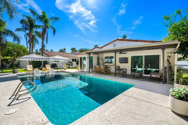 a view of a house with swimming pool and porch with furniture