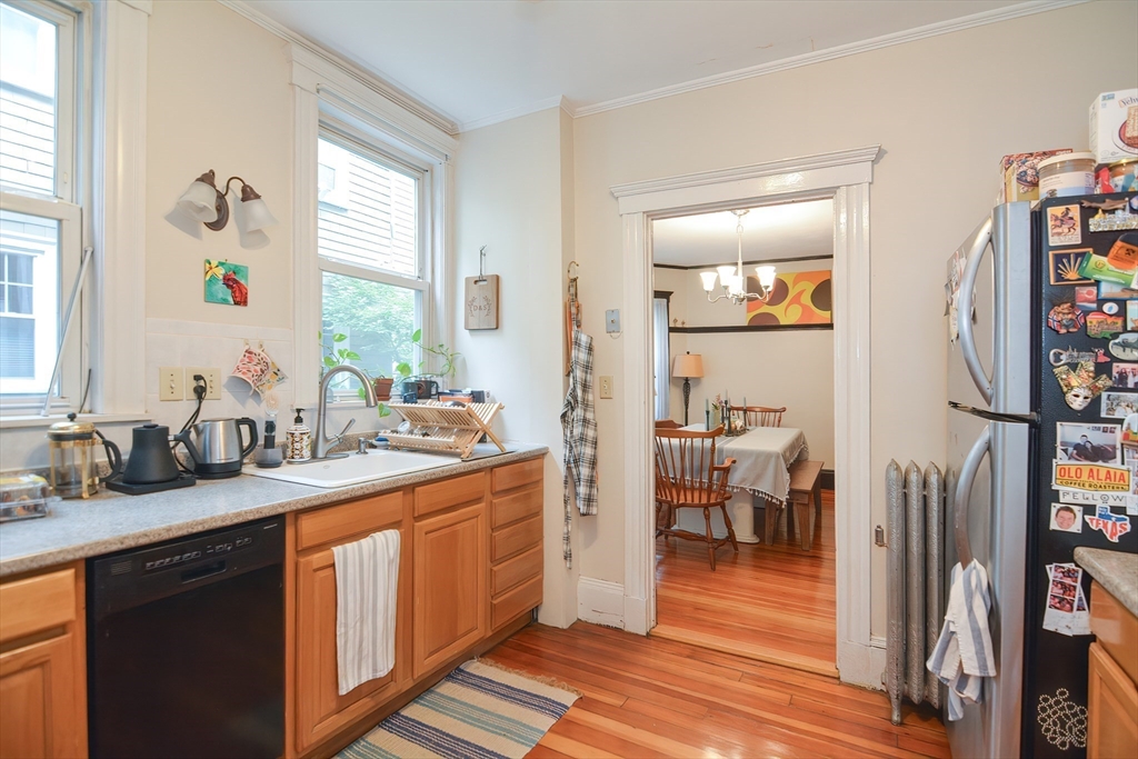 94 Browne Street Brookline, MA 02446 - Photo 12 of 35 a kitchen with stainless steel appliances granite countertop a refrigerator a sink dishwasher a stove and white countertops with wooden floor