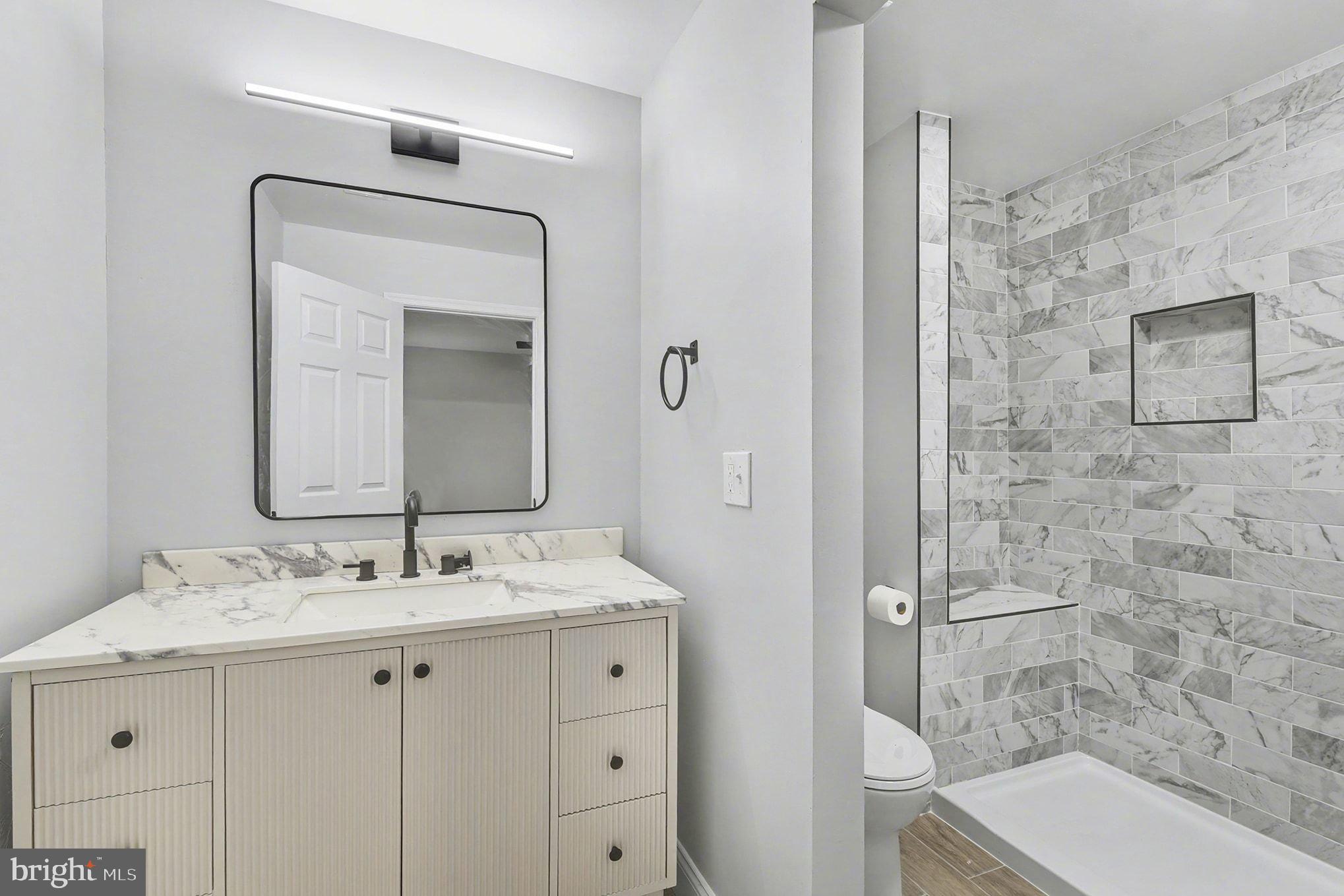 2 Winners Circle, Unit 1B Owings Mills, MD 21117 - Photo 21 of 39 a bathroom with a sink a toilet and shower