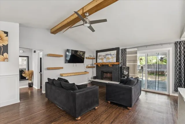 a living room with furniture a flat screen tv and a fireplace