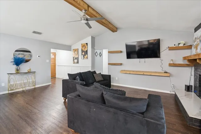 a living room with furniture a flat screen tv and a fireplace