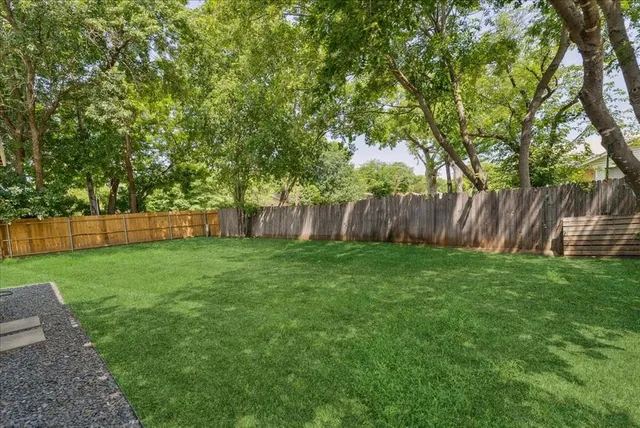 a view of a backyard with a garden and entertaining space