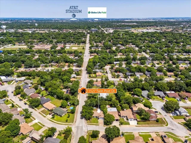 an aerial view of residential houses with outdoor space and trees