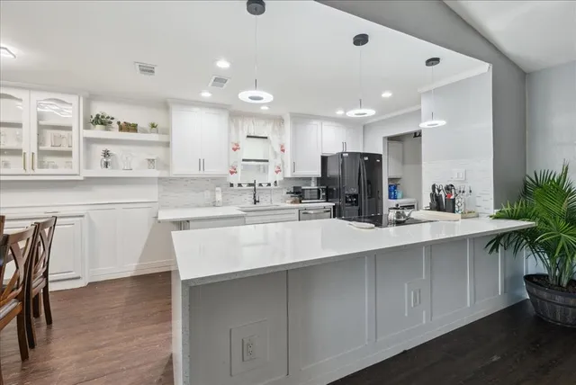a kitchen with kitchen island a sink stainless steel appliances and cabinets