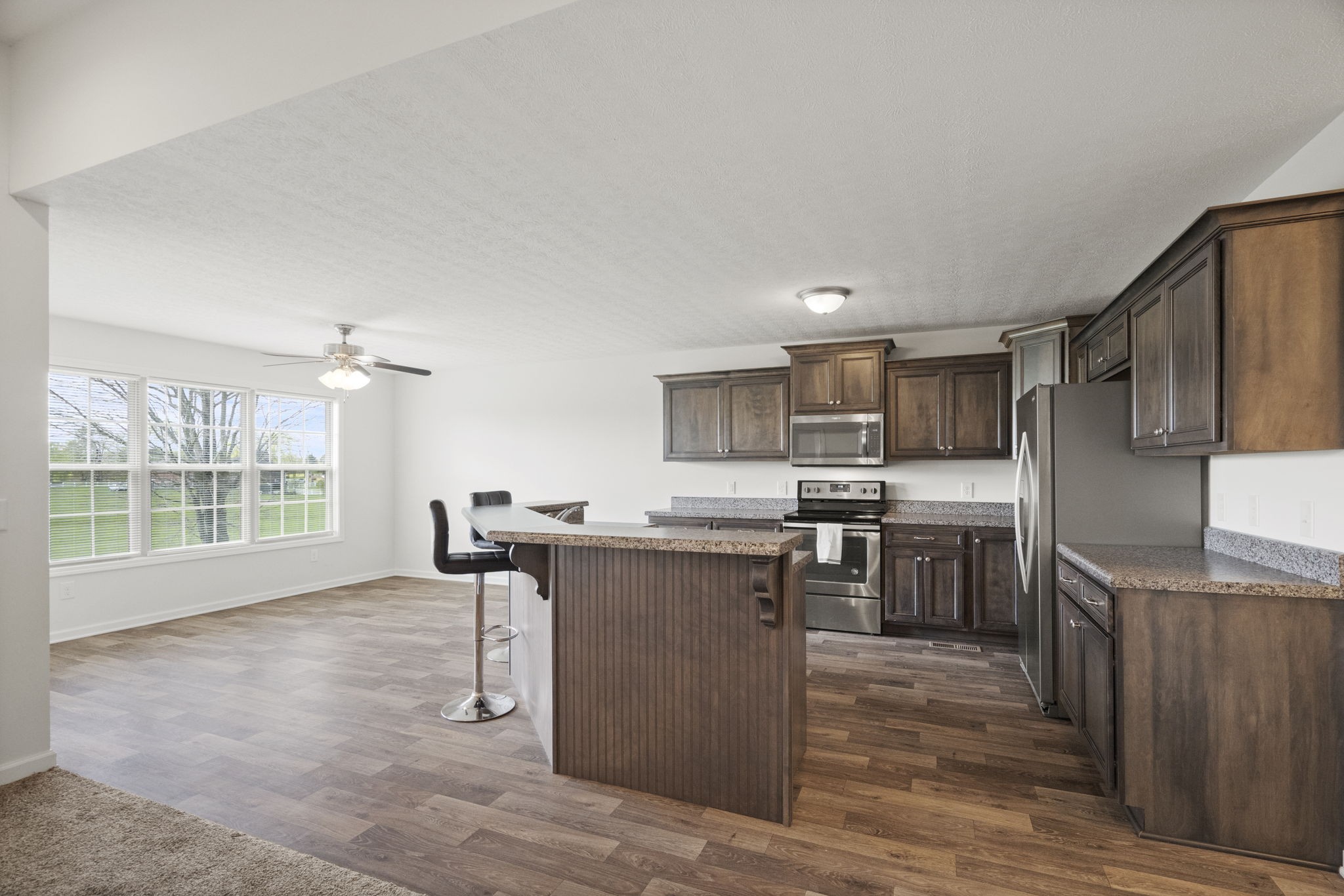 207 B Fountainhead Road Portland, TN 37148 - Photo 6 of 21 a kitchen with stainless steel appliances granite countertop a stove top oven a sink dishwasher a refrigerator and a dining table with wooden floor