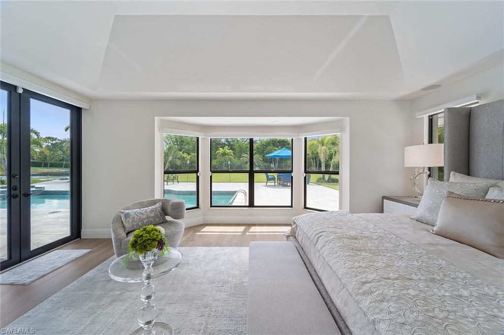 6582 Trail Boulevard Naples, FL 34108 - Photo 15 of 50 a spacious bedroom with a large bed and a large window