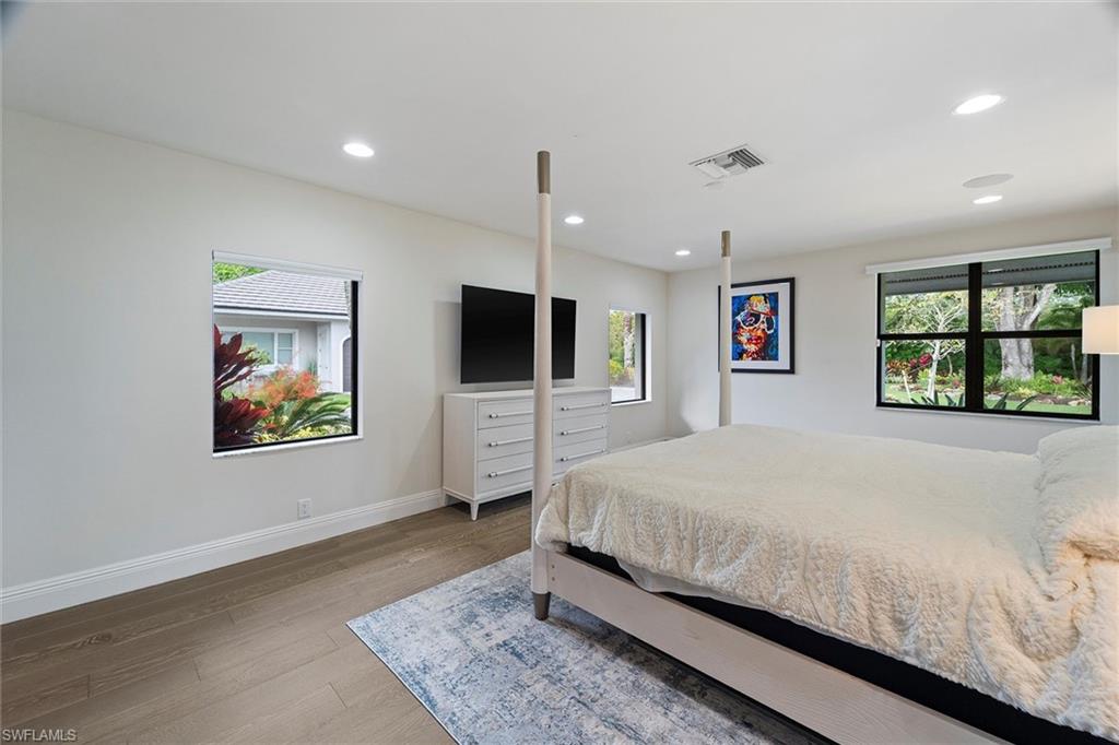 6582 Trail Boulevard Naples, FL 34108 - Photo 43 of 50 a bedroom with a large bed a tv and a window