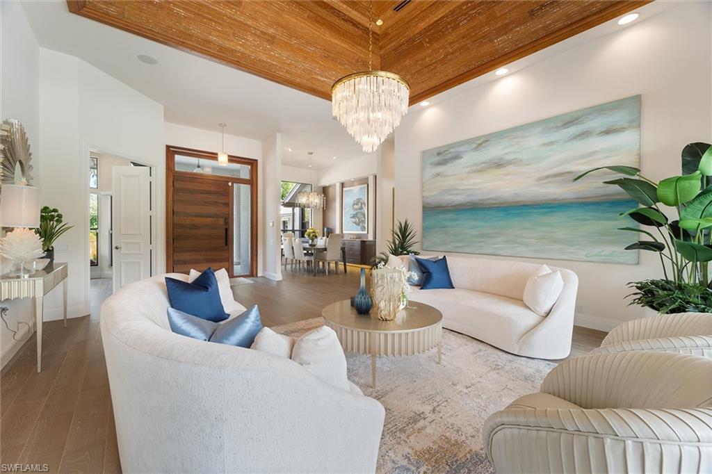 6582 Trail Boulevard Naples, FL 34108 - Photo 9 of 50 a living room with furniture a chandelier and a chandelier