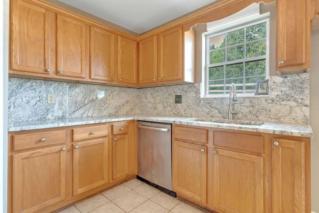 a kitchen with granite countertop white cabinets and sink