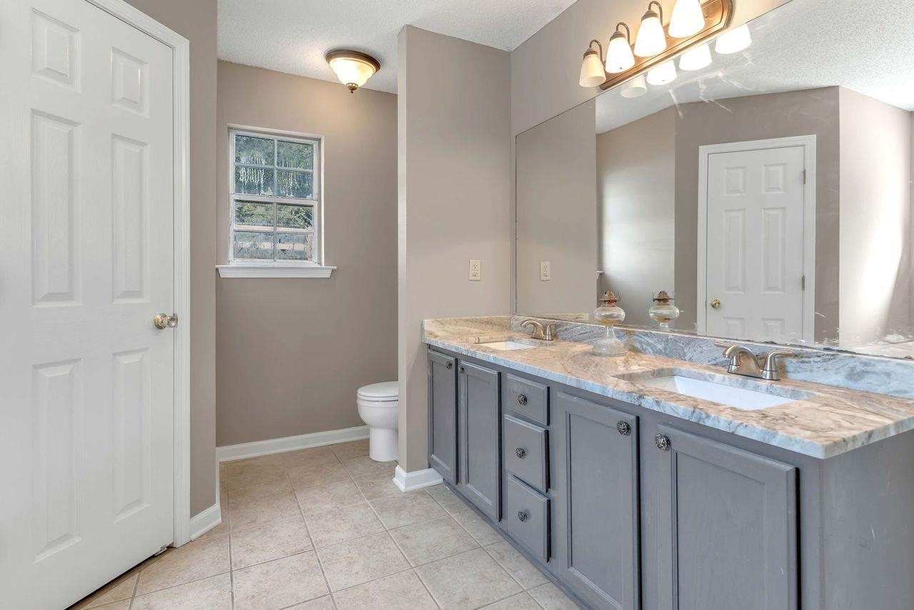 1088 Akins Store Road Munford, TN 38058 - Photo 16 of 40 a bathroom with a granite countertop sink mirror and a