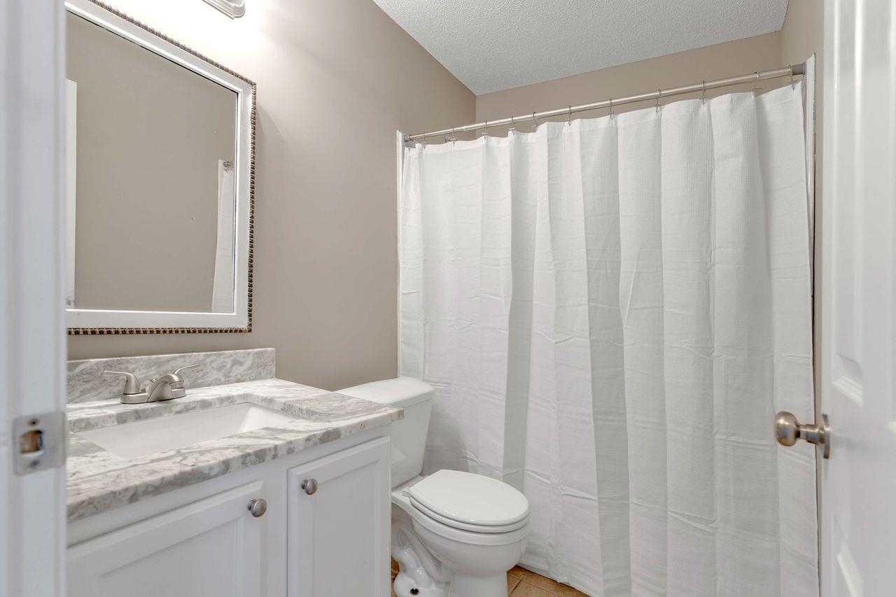 1088 Akins Store Road Munford, TN 38058 - Photo 22 of 40 a bathroom with a granite countertop sink toilet and a mirror
