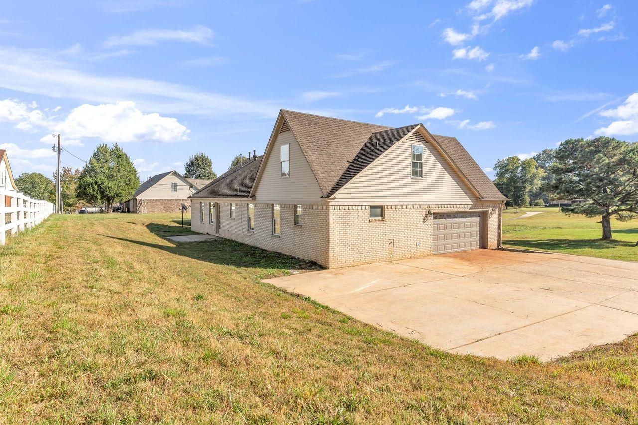 1088 Akins Store Road Munford, TN 38058 - Photo 31 of 40 a front view of a house with a yard and garage