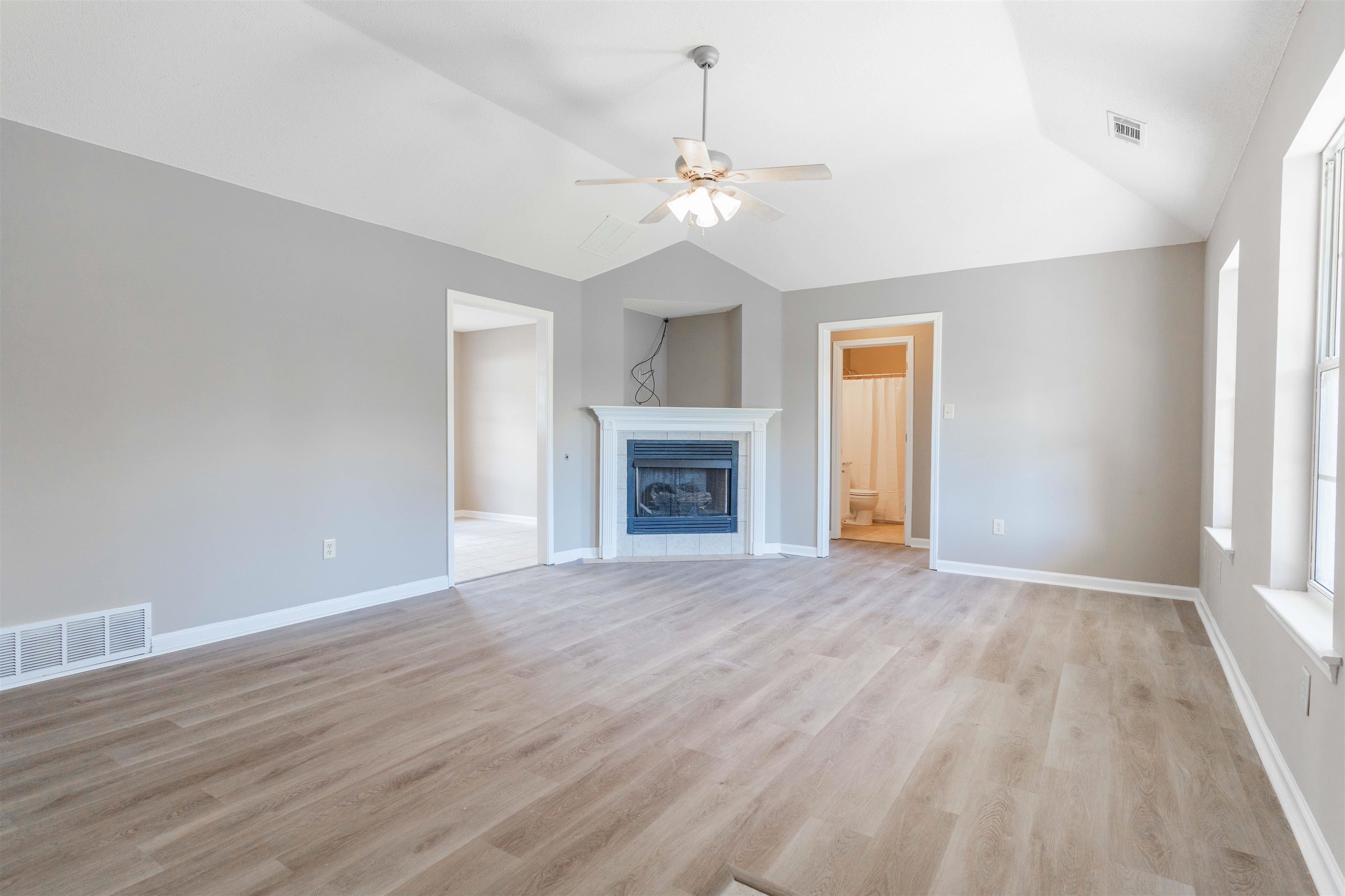 1088 Akins Store Road Munford, TN 38058 - Photo 5 of 40 an empty room with wooden floor fireplace and windows