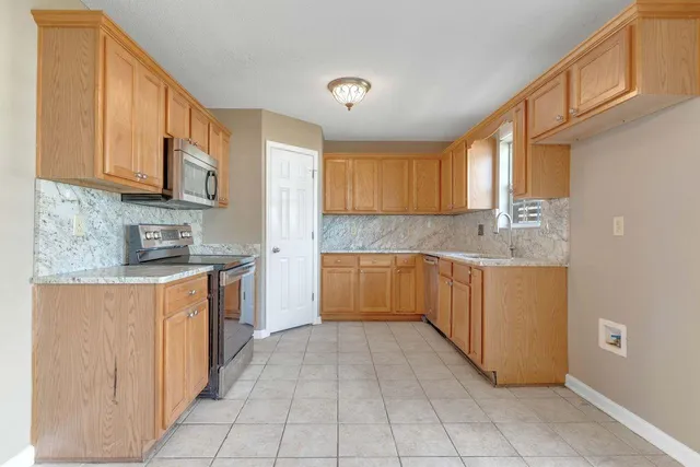a kitchen with stainless steel appliances granite countertop a stove a sink and a refrigerator