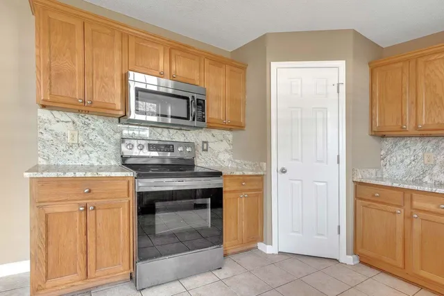 a kitchen with stainless steel appliances granite countertop a stove and a microwave oven