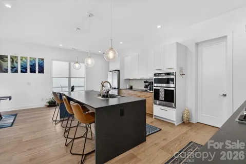 a kitchen with stainless steel appliances granite countertop a sink a stove and a refrigerator