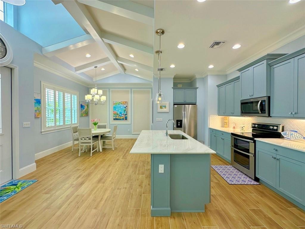 a large kitchen with stainless steel appliances kitchen island granite countertop a sink and cabinets