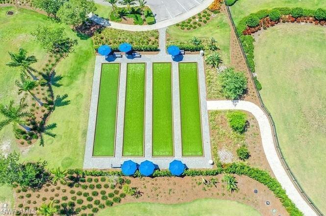 7270 Saona Court Naples, FL 34113 - Photo 30 of 46 a view of a garden with a bench