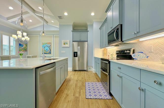 7270 Saona Court Naples, FL 34113 - Photo 3 of 46 a kitchen with stainless steel appliances granite countertop a refrigerator a sink dishwasher a stove and white cabinets with wooden floor