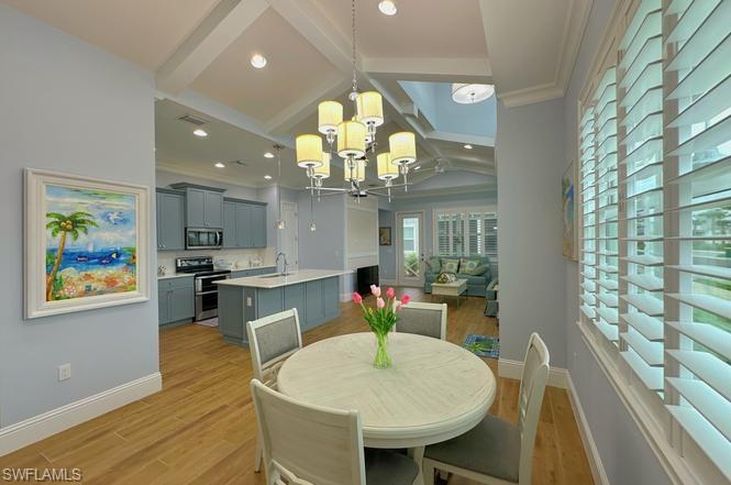 7270 Saona Court Naples, FL 34113 - Photo 5 of 46 a view of a dining room with furniture a chandelier and wooden floor
